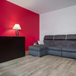 Rénovation partielle de maison à Sassenage (38) - grand salon mur rouge et sol imitation parquet