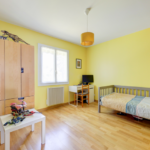 Rénovation d’une maison à Francheville (69) - chambre jaune avec parquet